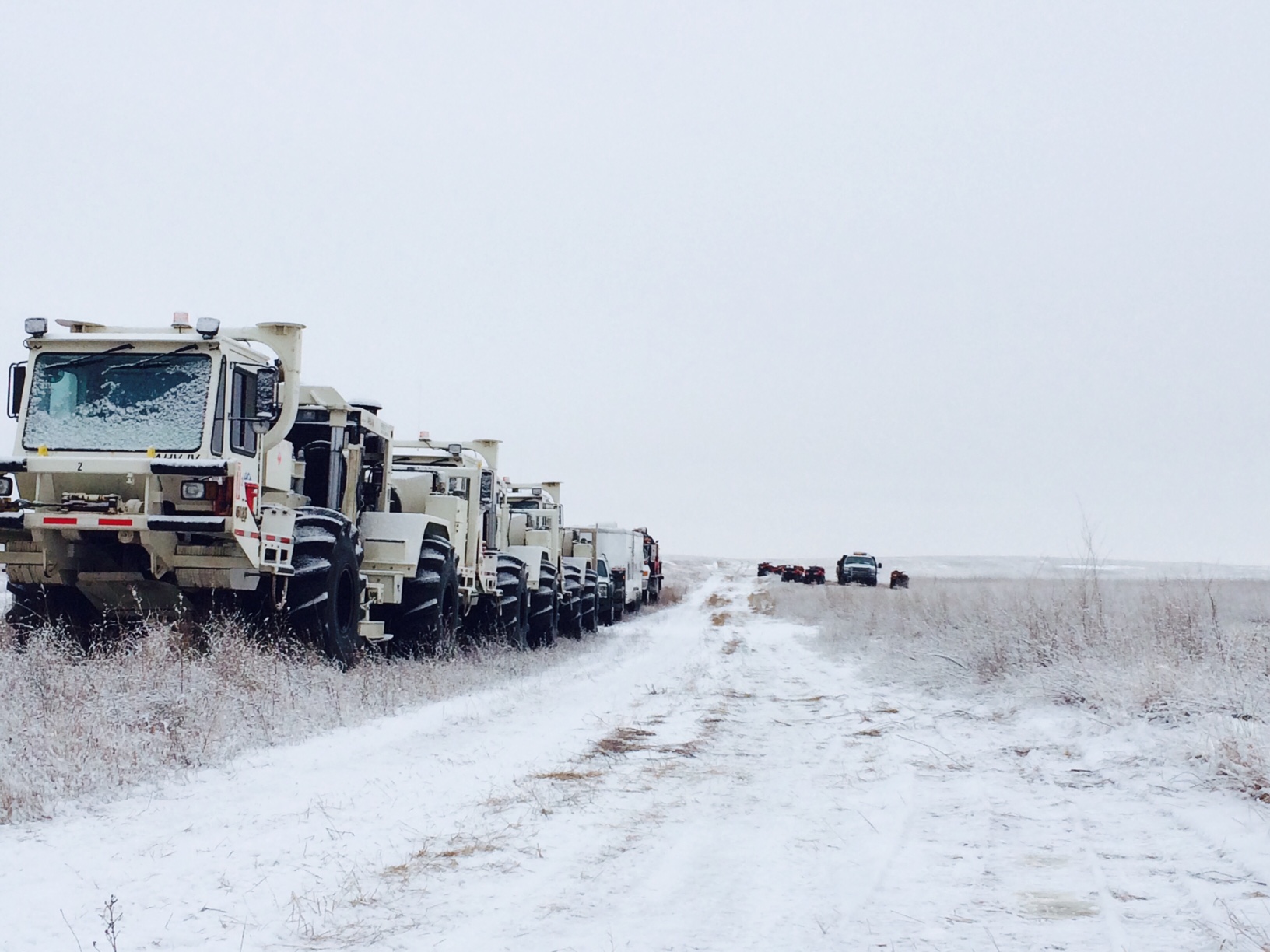 Vibroseis trucks lined up to provide seismic sources at Aquistore